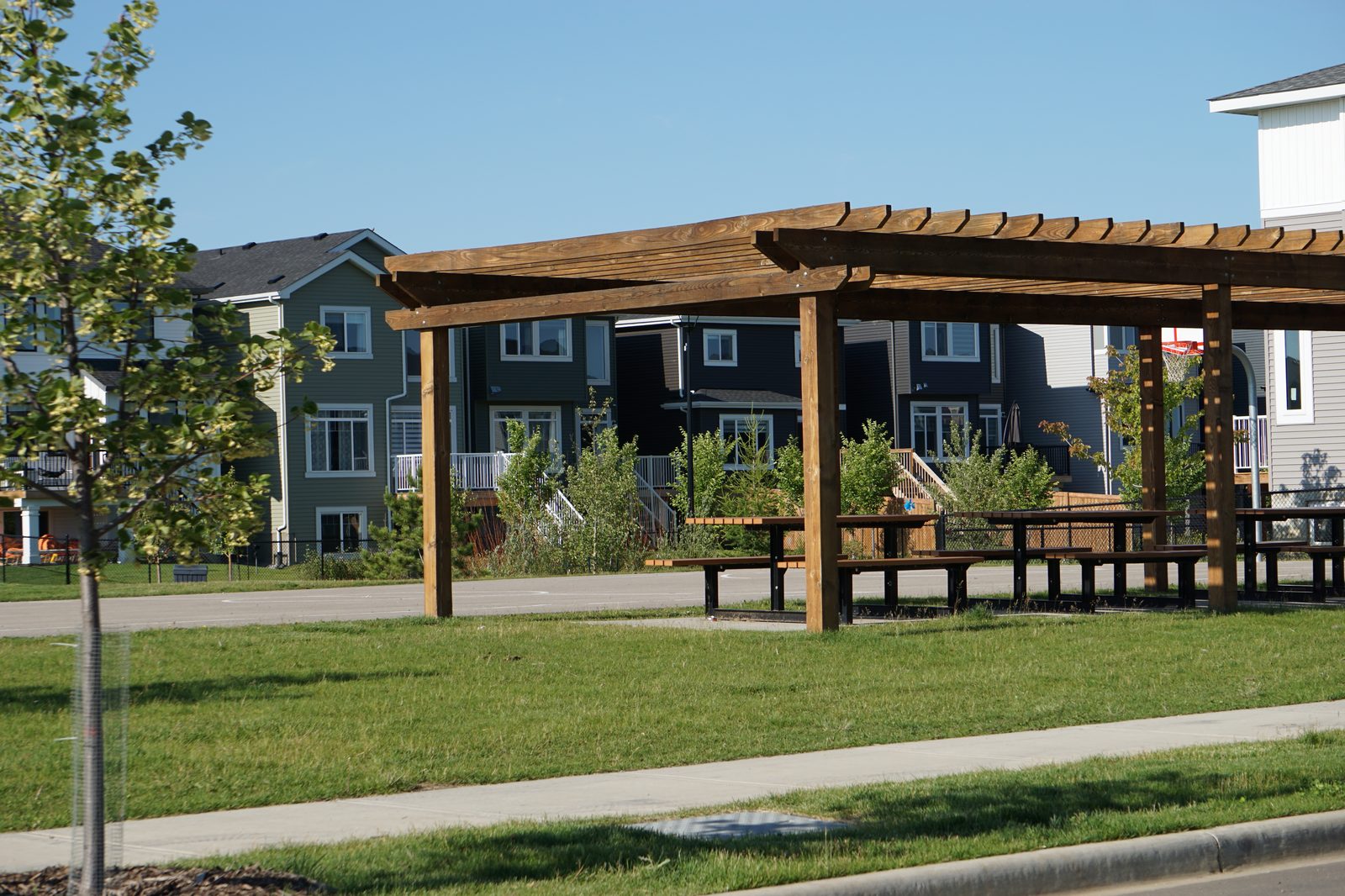 Pergola and picnic area at Parc Réunis with Élan homes in the background