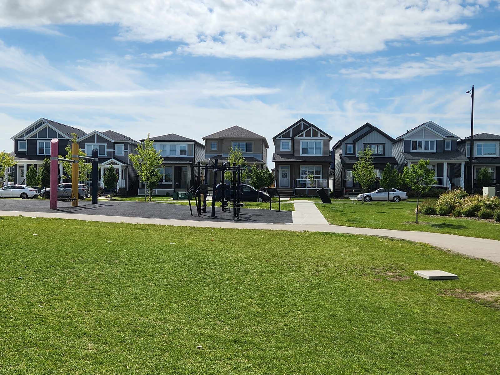 Porch-front homes facing a park with outdoor exercise equipment in Élan, Beaumont